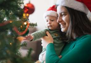 mama und baby vor dem weihnachtsbaum